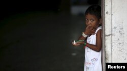 A young Rohingya migrant who arrived in Indonesia last week by boat eats a snack at a temporary shelter in Aceh Timur regency near Langsa in Indonesia's Aceh Province, May 26, 2015. 