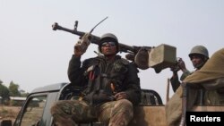 Congolese government army soldiers ride on their truck as they patrol Kibati village outside the eastern Congolese city of Goma, DRC, July 22, 2013. 