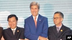 Vietnam Foreign Minister Pham Binh Minh (L), U.S. Secretary of State John Kerry (C), and an unidentified delegate from Malaysia, pose for a group photo as they shake hands during the ASEAN-U.S., on July 25, 2016.