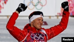 Winner Switzerland's Dario Cologna celebrates during a flower ceremony for the men's 15 km cross-country classic event at the Sochi 2014 Winter Olympic Games in Rosa Khutor, Feb. 14, 2014. 