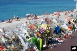 FILE - Flowers and messages are placed along the beach of the Promenade des Anglais in Nice, southern France, July 20, 2016.