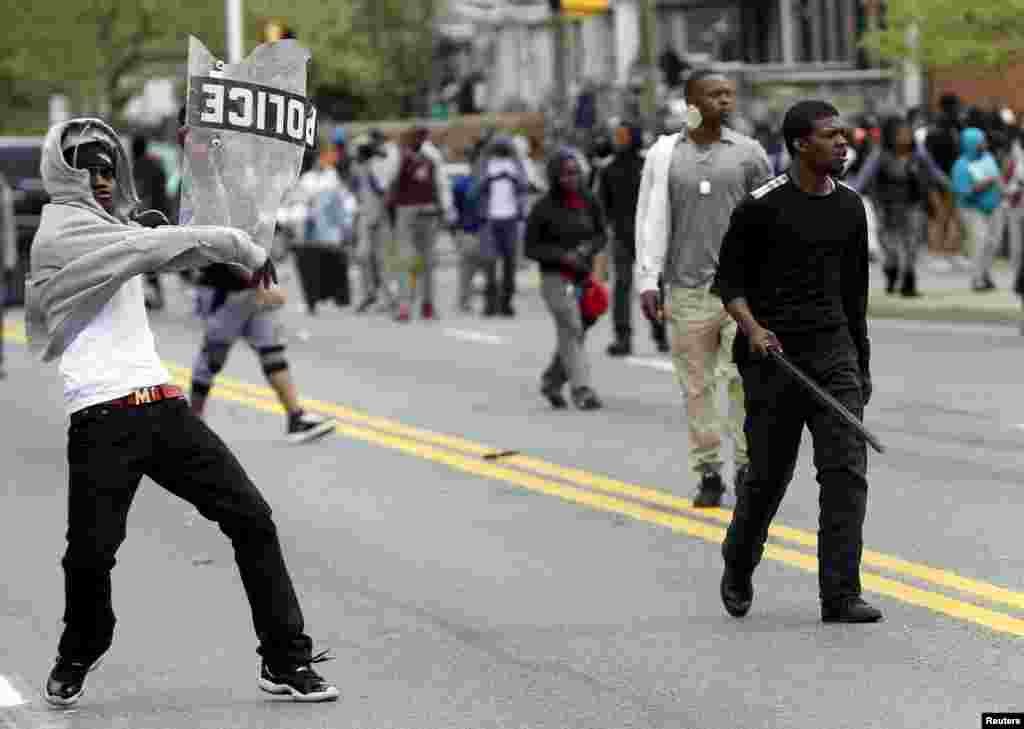 Manifestantes atiram pedras contra a polícia durante confrontos em Baltimore, Maryland, Abril 27, 2015.