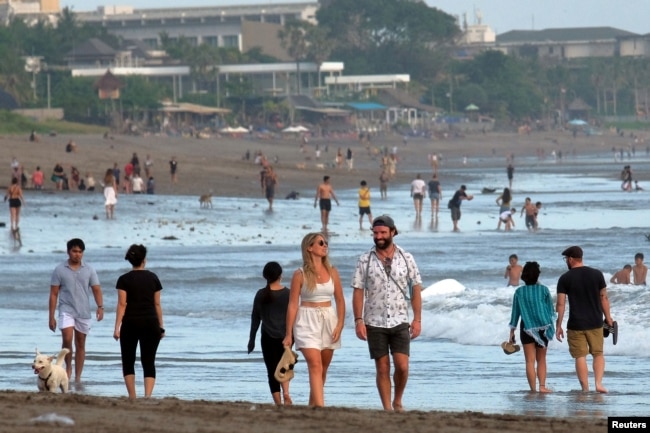 Turis berjalan di pantai saat pemerintah memperpanjang PPKM di Badung, Bali, 9 September 2021. (Foto: Antara/Nyoman Hendra Wibowo via REUTERS)