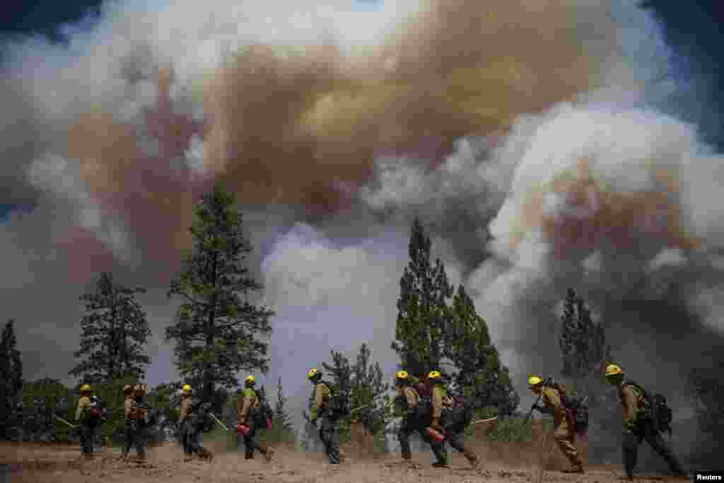 Los Angeles County firefighters hike in on a fire line on the Rim Fire near Groveland, California, USA, Aug. 22, 2013. The wildfire raging out of control near Yosemite National Park in northern California ballooned to nearly 54,000 acres, more than tripling in size from the day before, forest officials said.