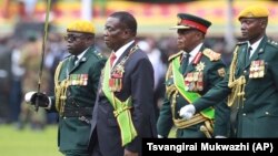 FILE: Emmerson Mnangagwa, second left, with Army General Constantino Chiwenga, second right, inspects the military parade after being sworn in as President at the presidential inauguration ceremony in the capital Harare, Zimbabwe Friday, Nov. 24, 2017.