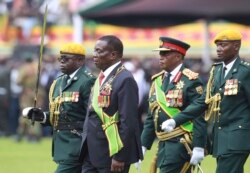 FILE: Emmerson Mnangagwa, second left, with Army General Constantino Chiwenga, second right, inspects the military parade after being sworn in as President at the presidential inauguration ceremony in the capital Harare, Zimbabwe Friday, Nov. 24, 2017.