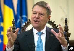 FILE - Romanian President Klaus Iohannis speaks with an AP reporter at the Cotroceni Palace in Bucharest, Romania, Feb. 8, 2017.
