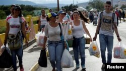 Người dân Venezuela xách những túi nhu yếu phẩm mua được từ Colombia, ở San Antonio del Tachira, Venezuela, 10/7/2016.