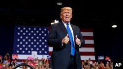 President Donald Trump gives a thumbs-up as he arrives to a campaign rally, Sept. 20, 2018, in Las Vegas.