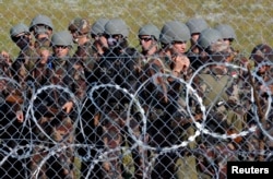 Hungarian soldiers arrive at the border near Roszke, Hungary, September 14, 2015.