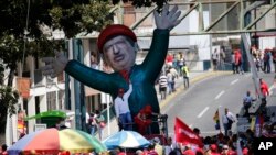 Un muñeco inflable del fallecido presidente, Hugo Chávez, afuera del palacio presidencial de Miraflores, durante una marcha en defensa de la petrolera estatal PDVSA. Caracas, Venezuela. Photo: AP