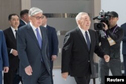 FILE - Kassym-Jomart Tokayev, left, then-interim president of Kazakhstan, and former President Nursultan Nazarbayev attend the Astana Economic Forum in Nur-Sultan, Kazakhstan, May 16, 2019.
