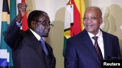 FILE: Zimbabwe's President Robert Mugabe (L) gestures as South Africa's President Jacob Zuma looks on at the end of a press briefing at the Union building in Pretoria, April 8, 2015.