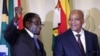 FILE - Zimbabwe's President Robert Mugabe (L) gestures as South Africa's President Jacob Zuma looks on at the end of a press briefing at the Union building in Pretoria, April 8, 2015.