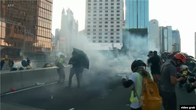 香港示威者在金钟夏悫道与警方爆发冲突，警方施放催泪弹等武力驱赶堵路示威者（视频截图）