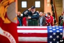 A mourner salutes the casket of John Glenn as he lies in honor in Columbus, Ohio, Dec. 16, 2016.