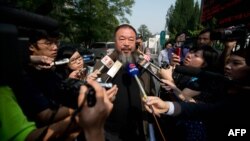 Outside a court in Beijing, Chinese artist Ai Weiwei (C) talks to the foreign media says the court rejected his appeal regarding a $2.4 million fine for tax evasion, Sept. 27, 2012.