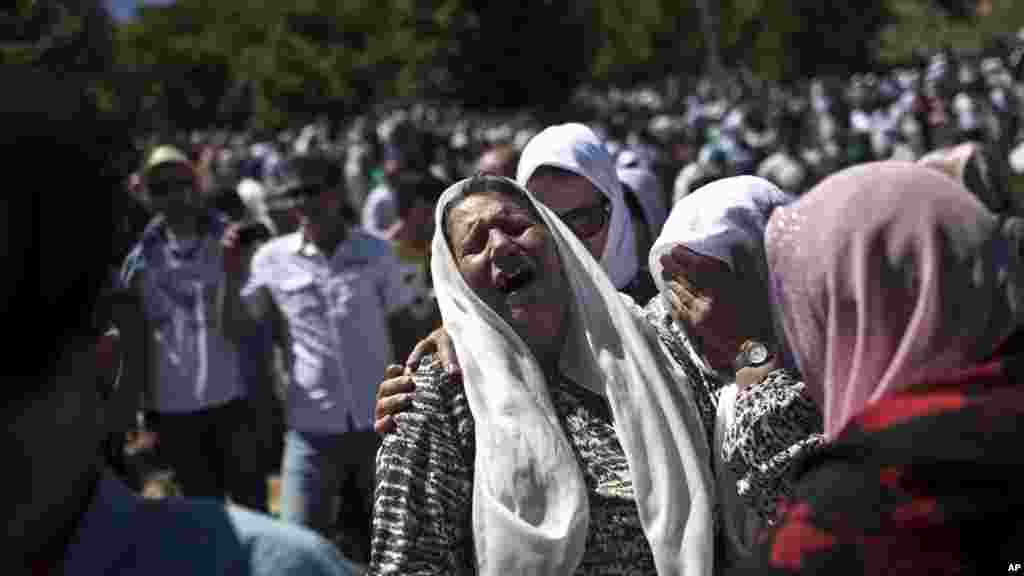 A woman cries as the remains of her son are buried at the Potocari memorial complex near Srebrenica, 150 kilometers northeast of Sarajevo, Bosnia and Herzegovina, July 11, 2015. 