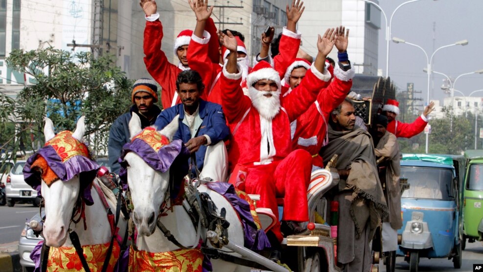 Para pria berpakaian Sinterklas untuk menyambut Natal di Lahore, Pakistan, Jumat (23/12). Pemerintah Pakistan juga meluncurkan kereta api khusus yang bertemakan Natal mulai Kamis (22/12) malam.
