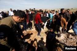 Mourners carry one of the victims who died after an overloaded ferry sank in Tigris river near Mosul, during his funeral at Mosul cemetery, Iraq, March 22, 2019.