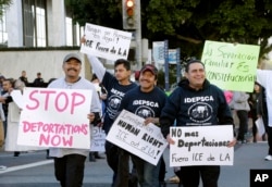 FILE - Immigration activists march in a rally against the U.S. Immigration and Customs Enforcement's (ICE) raids and deportation of immigrants near the downtown Los Angeles Federal Building, Jan. 26, 2016.