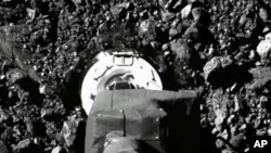 Dalam gambar dari video yang dipublikasikan NASA ini, pesawat ruang angkasa Osiris Rex menghantam permukaan asteroid Bennu pada Selasa, 20 Oktober 2020.  (NASA melalui AP)