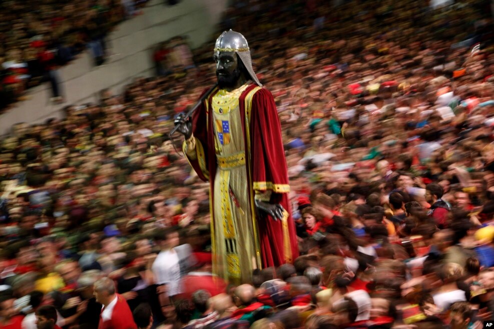 A figure of a giant stands as revellers take part in the Patum in the Catalan village of Berga, Spain. The Patum of Berga is a popular festival whose origin can be traced to medieval festivities that is celebrated each year in the Catalan city of Berga during Corpus Christi.