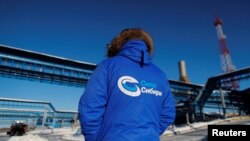 FILE - An employee in jacket reading "Power of Siberia" is seen at the Atamanskaya compressor station facility of Gazprom's "Power of Siberia" gas pipeline outside the far eastern town of Svobodny, in Russia's Amur region, Nov. 29, 2019.