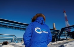 Seorang karyawan mengenakan jaket bertuliskan "Power of Siberia" di fasilitas stasiun kompresor Atamanskaya dari pipa gas "Power Of Siberia" Gazprom di luar kota timur jauh Svobodny, wilayah Amur Rusia, 29 November 2019. (REUTERS)