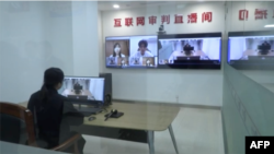 Video screens show citizens taking part in an "internet court" system, based in Hangzhou, China. (Courtesy: AFP/YouTube video)