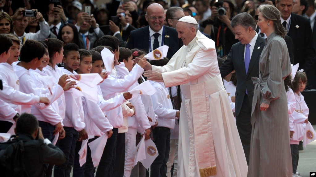 Colombia's President Juan Manuel Santos, second from right, and his wife Maria Clemencia Rodriguez accompany Pope Francis who is greeted by children upon his arrival to El Dorado airport in Bogota, Colombia, Sept. 6, 2017.