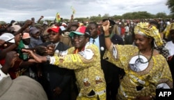 FILE: Zimbabwe's President Robert Mugabe (C) greets supporters with his wife Grace in Tsholotsho whilst on the campaign trail, 23 March 2005.