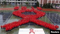 ນັກສຶກສາຢືນລຽນແຖວກັນເປັນຮູບໂບແດງ ໃນຂະນະທີ່ ທໍາການປຸກລະດົມ ຊຸກຍູ້ຄວາມຕື່ນຕົວກ່ຽວກັບໂຣກ HIV/AIDS ຢູ່ນະຄອນໄທເປ ໃນວັນທີ 30 ພະຈິກ 2012 ເພື່ອເປັນການສະຫລອງວັນແຫ່ງໂຣກເອດສ໌ ທີ່ຈະຈັດຂຶ້ນໃນວັນທີ 1 ທັນວາ 2012. REUTERS/Pichi Chuang (TAIWAN - Tags: SOCIETY HEALTH)