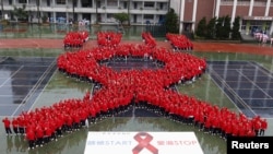 Students form a giant red ribbon during a publicity campaign to promote awareness about HIV/AIDS in Taipei November 30, 2012. World AIDS Day 