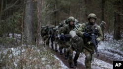 FILE - Lithuanian conscripts practice during a NATO military exercise at the Rukla military base west of the capital Vilnius, Lithuania, Nov. 28, 2016.