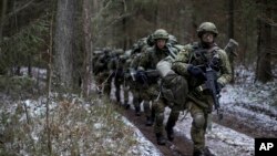 Lithuanian troops practice during a NATO military exercise, 'Iron Sword,' at the Rukla military base some 130 km. (80 miles) west of the capital Vilnius, Lithuania, on Monday, Nov. 28, 2016. (AP Photo/Mindaugas Kulbis)