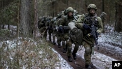 Lithuanian troops practice during a NATO military exercise, 'Iron Sword,' at the Rukla military base some 130 km. (80 miles) west of the capital Vilnius, Lithuania, on Monday, Nov. 28, 2016. (AP Photo/Mindaugas Kulbis)