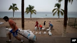 23일 멕시코 푸에르토발라르타 주민들이 허리케인 퍼트리샤에 대비해 해안 상가 주변에 모래주머니를 쌓고 있다.