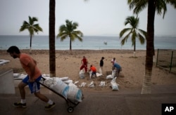 Residents prepare for the arrival of Hurricane Patricia filling sand bags to protect beachfront businesses, in Puerto Vallarta, Mexico, Oct. 23, 2015.