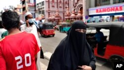 Seorang perempuan Sri Lanka mengenakan burka di jalanan yang ramai di Kolombo, 13 Maret 2021. (AP Photo/Eranga Jayawardena)