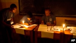 Electoral workers count election ballots by candle light in Port-au-Prince, Haiti, Sunday, Nov. 20, 2016. 