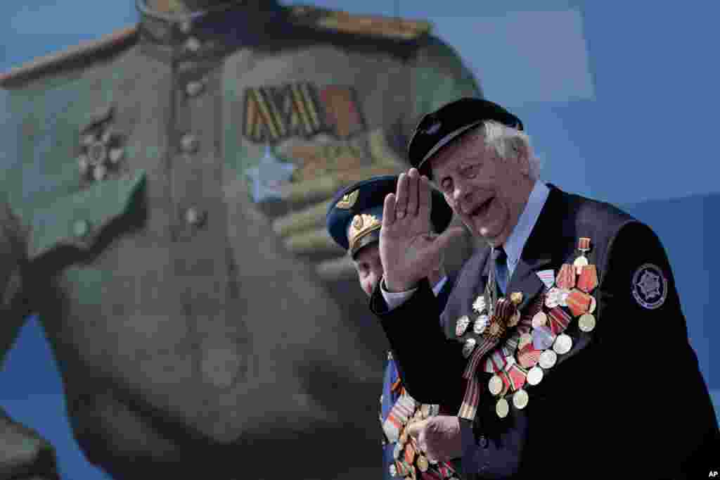 An unidentified Russian WWII veteran salutes as he walks, after the Victory Parade marking the 70th anniversary of the defeat of the Nazi Germany in World War II, in Red Square, Moscow, May 9, 2015.