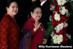 Mantan Presiden Indonesia Megawati Soekarnoputri melambai kepada wartawan saat ia tiba bersama putrinya Puan Maharani. (Foto: Reuters)