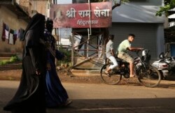 FILE - Muslim women walk in a residential neighborhood in Belagavi, India, Oct. 7, 2021. Police in India have arrested a man alleged to be behind an online 'auction' of pictures of Muslim women in a case of apparent hatred toward the minority community.