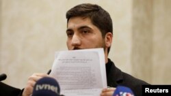 Osama Abu Zaid, a spokesman for the Free Syrian Army rebel alliance, shows the text of the agreement about a cease-fire between Syrian opposition groups and the Syrian government during a news conference in Ankara, Turkey, Dec. 29, 2016. 