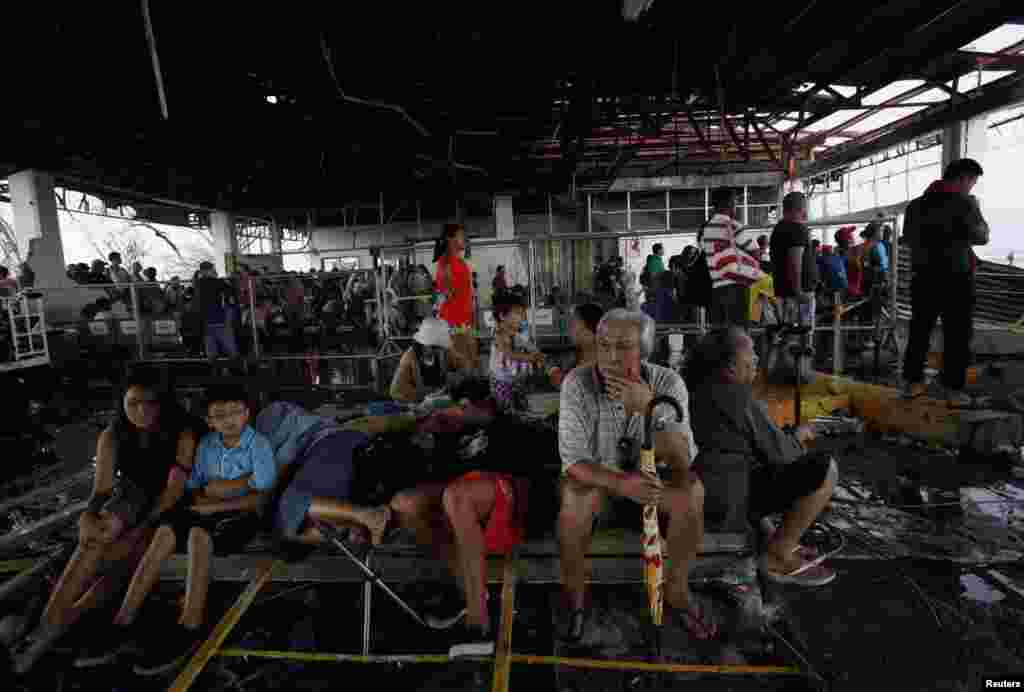 Moradores esperam ser evacuados por voos militares dentro do terminal do aeroporto em Tacloban.