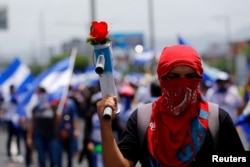 Los partidarios del presidente de Nicaragua, Daniel Ortega, muestran fotos de policías muertos, que perdieron la vida durante las últimas protestas, en una manifestación en Managua, Nicaragua el 21 de julio de 2018. REUTERS / Jorge Cabrera -
