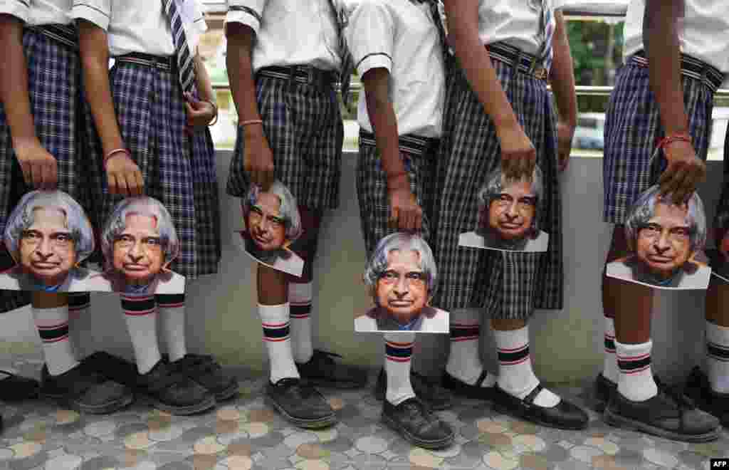 Indian schoolchildren hold masks bearing the image of former Indian president A.P.J Kalam ahead of the first anniversary of his death during a remembrance event at a school in Chennai.