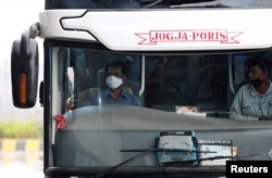 Seorang supir bus mengenakan masker wajah di terminal bus Pulo Gebang di tengah wabah virus corona (Covid-19) di Jakarta, 12 April 2020. (Foto: Reuters)