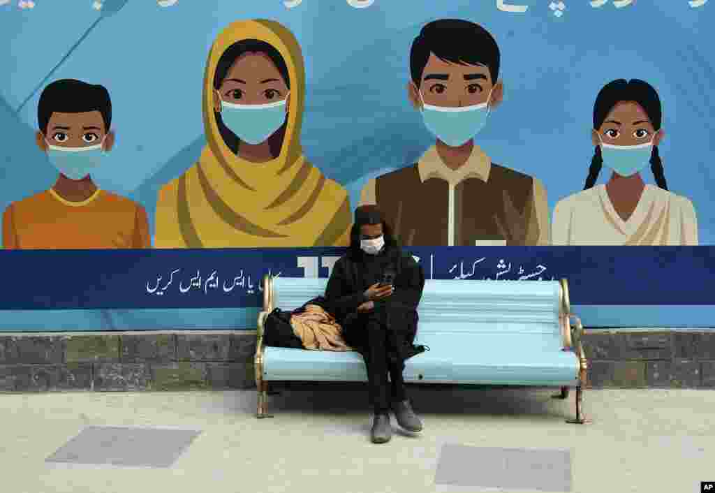 A man waits his turn to receive a dose of the COVID-19 vaccine at a vaccination center, in Peshawar, Pakistan.